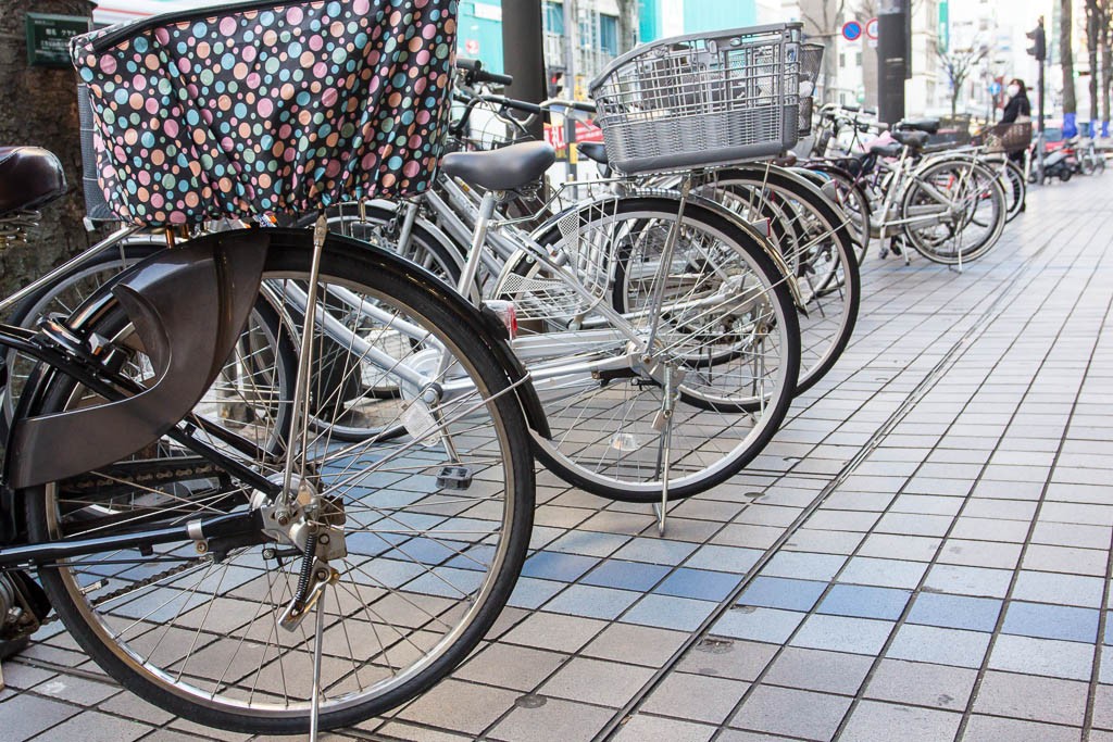 Rows of bikes parked on the street. Everyone rides the big beach cruiser style bikes here.  Usually with a couple baskets tied on. 