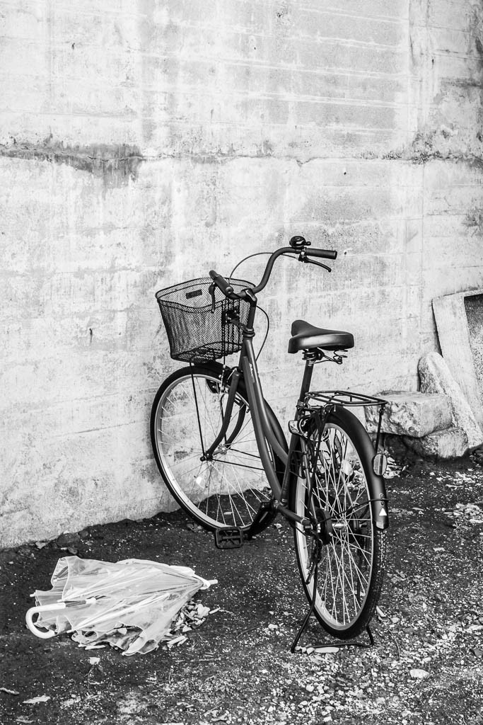 Lonely bicycle and discarded umbrella under a bridge. Moodiest bike ever.  