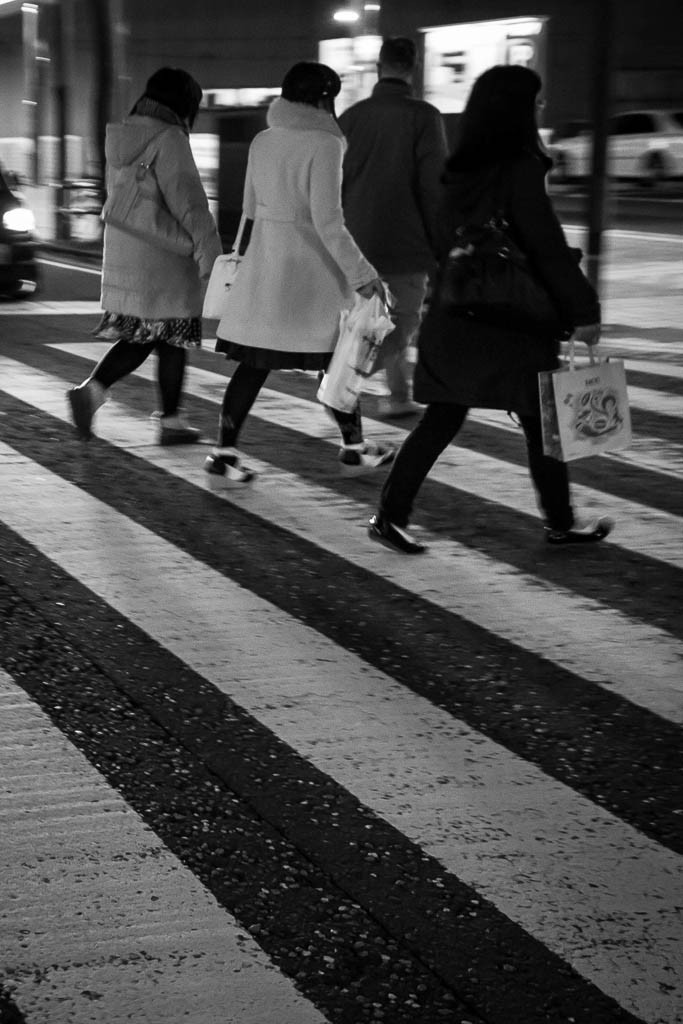 On the crosswalk.  Like the line of people parallel with the lines on the road. I believe this was one of my random snaps while walking.  Every once in a while a blind squirrel finds a nut.