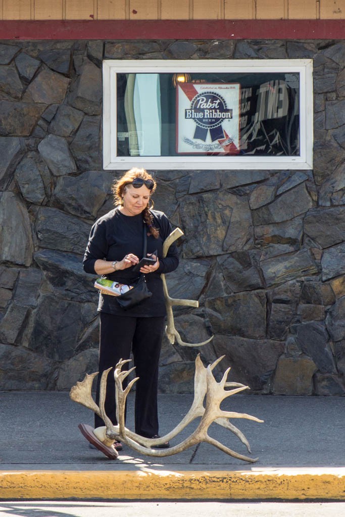 Just a women standing around with moose antlers...